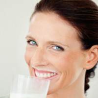 a woman drinking a glass of milk